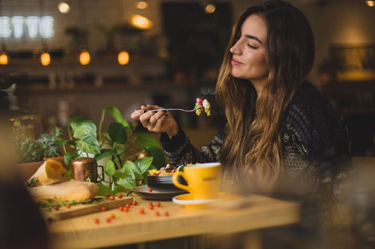 woman eating dinner before drinking tea for digestion