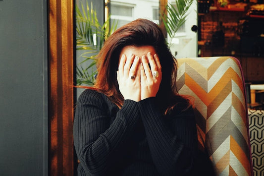 woman with hands over face waiting for tea for headaches